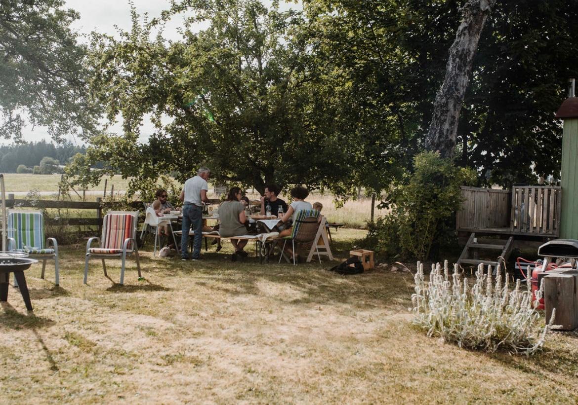 Familienessen im Garten unter Bäumen