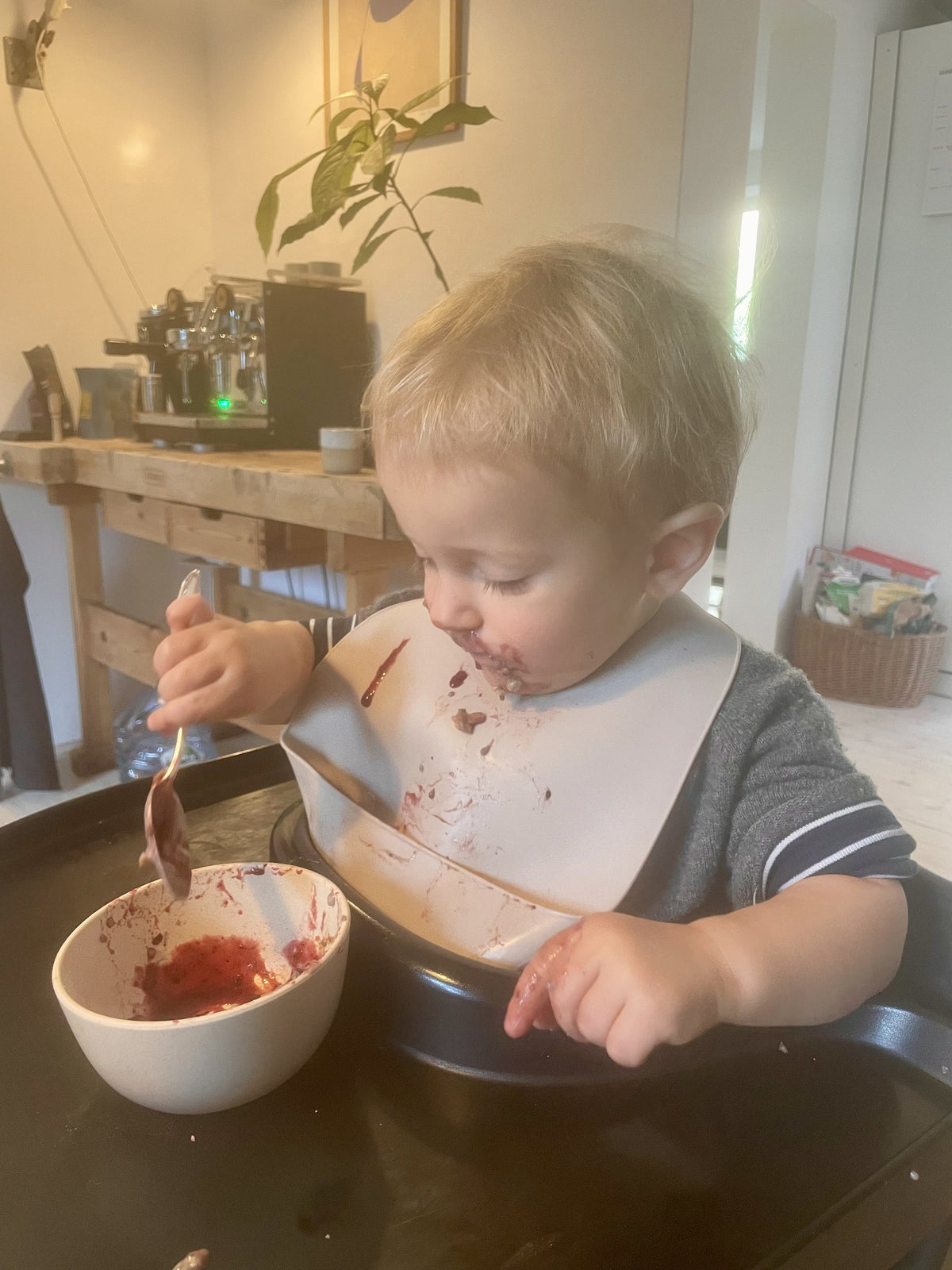 Kleinkind löffelt sein Frühstück