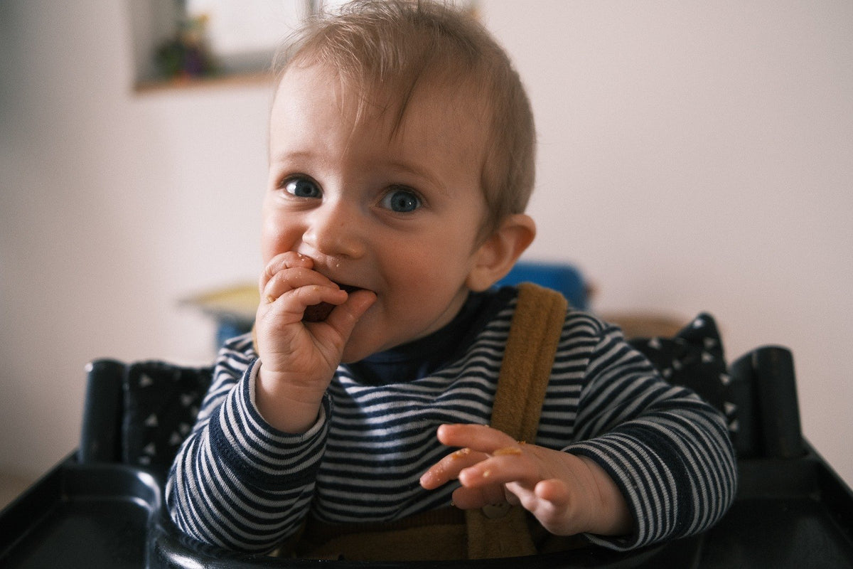 Baby im Hochstuhl beim Beikoststart